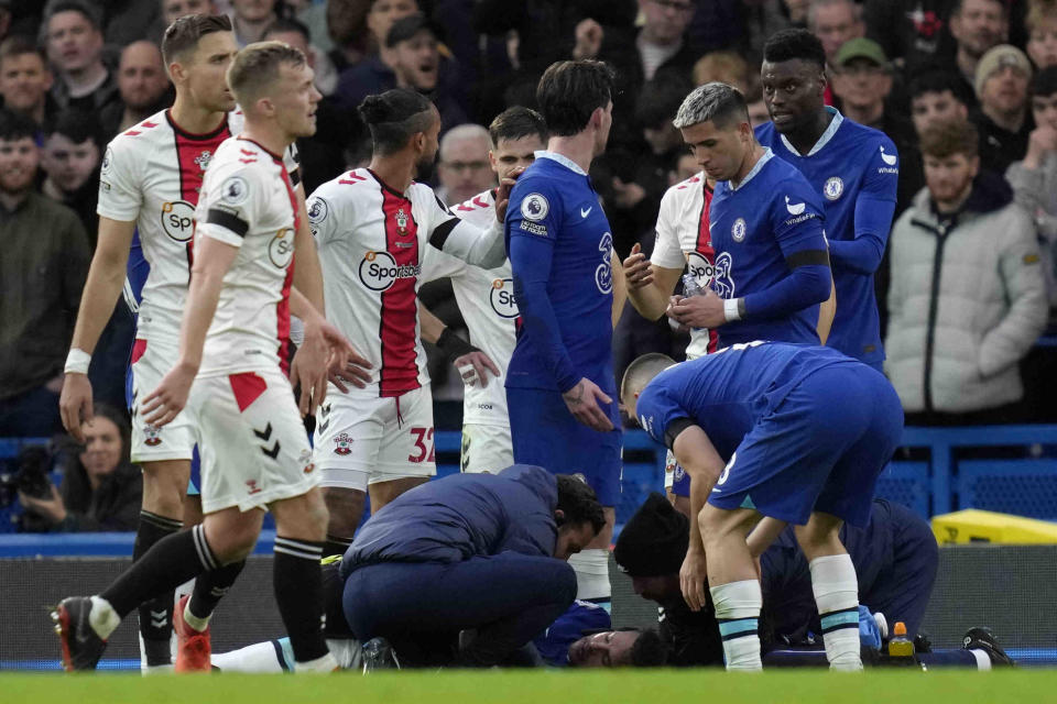 Players get around injured Chelsea's Reece James during the English Premier League soccer match between Chelsea and Southampton at the Stamford Bridge stadium in London, Saturday, Feb. 18, 2023. (AP Photo/Kirsty Wigglesworth)