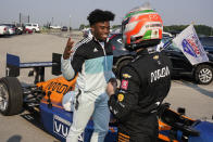 Indianapolis Colts cornerback Kenny Moore II, left, thanks IndyCar driver Pato O'Ward for a ride into the Colts training camp in the back seat of a two-seat IndyCar as the players reported to the NFL team's football training camp in Westfield, Ind., Tuesday, July 27, 2021. Practice open on Wednesday. (AP Photo/Michael Conroy)