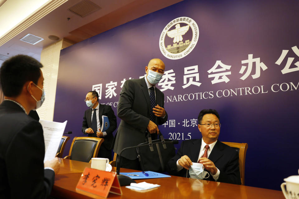 Deng Ming, deputy director of China's National Narcotics Control Commission, center leaves after attending a press conference in Beijing on Tuesday, May 11, 2021. China on Tuesday said it will add all synthetic cannabinoids to its list of banned drugs, in what it described as a first in the world, to curb their manufacturing, trafficking and abuse. (AP Photo/Ng Han Guan)