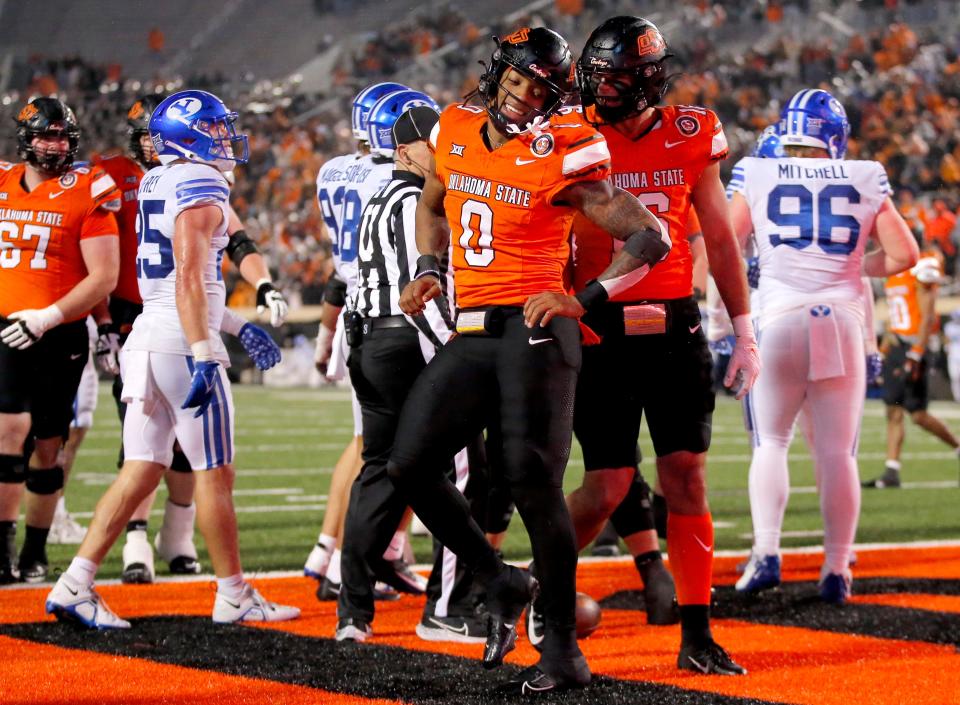 Oklahoma State's Ollie Gordon (0) reacts after a touchdown in the second half of the college football game between the Oklahoma State University Cowboys and the Brigham Young Cougars at Boone Pickens Stadium in Stillwater, Okla., Saturday, Nov. 25, 2023.