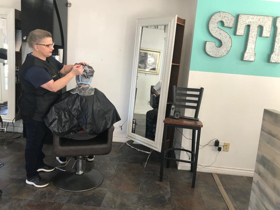 Cosmetologist Araceli Ayala works on a customer's hair at the Silver Strand Salon at Fisherman's Wharf. She doubts an amusement park would work at the location long term.