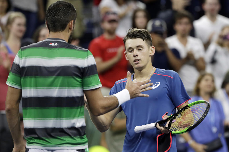Marin Cilic of Croatia, left, shakes hands with Alex de Minaur of Australia after defeating de Minaur in five sets in a third-round tennis match at the U.S. Open tennis championship, Sunday, Sept. 2, 2018, in New York. (AP Photo/Mark Lennihan)