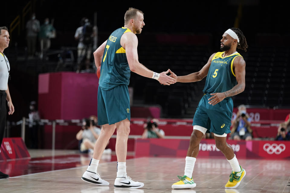 Australia's Joe Ingles, left, and Patty Mills (5) celebrate at the end of a men's basketball preliminary round game against Italy at the 2020 Summer Olympics, Wednesday, July 28, 2021, in Saitama, Japan. (AP Photo/Charlie Neibergall)