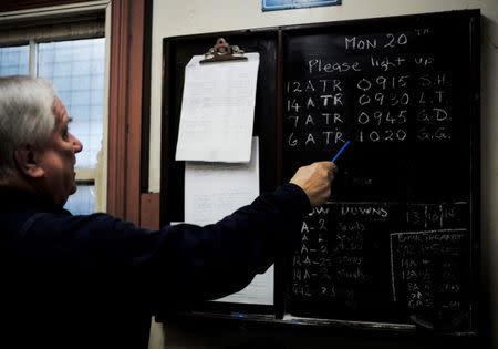 Puffing Billy steam engine driver Steve Holmes, 61, looks at the roster of steam locomotives and the initials of their assigned drivers before operating his train from Belgrave station near Melbourne, October 20, 2014. REUTERS/Jason Reed