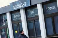 A police officer walks outside the Midnight Shisha bar after a shooting in Hanau