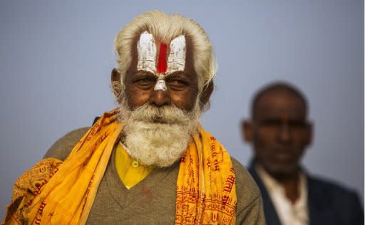 An Indian Hindu Sadhu (left) and a newly initiated Sadhu look on near their tent at the Kumbh Mela in Allahabad on February 19, 2013. Authorities at the festival on Sunday said the last batch of holy men marked the end of the Kumbh by plunging into the river Ganges and other pilgrims filled the "Ganga Jal" (holy water) in plastic bottles for religious ceremonies at home