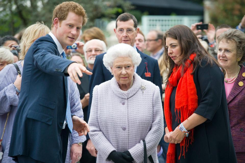 Harry points something out to the Queen while the pair visit the Sentebale Forget-Me-Not Garden at the Chelsea Flower Show in 2013. 