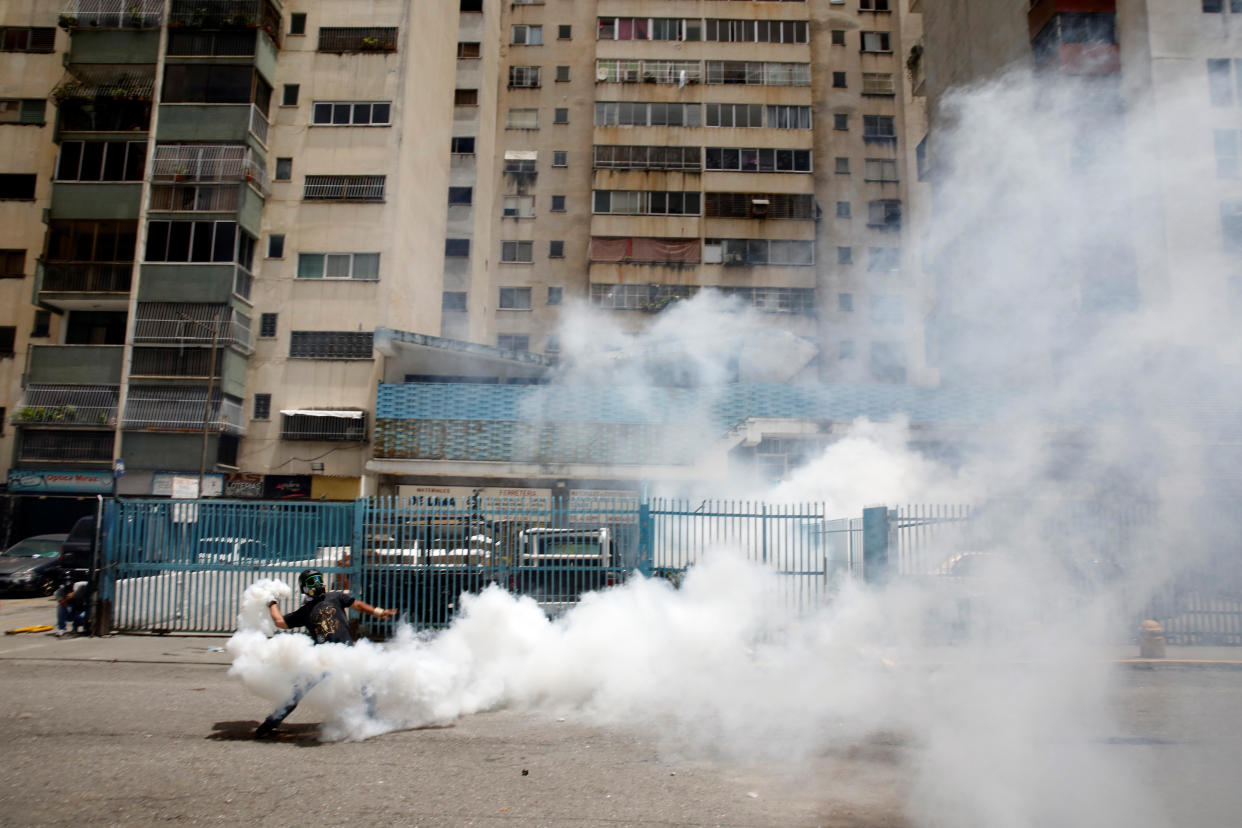 A demonstrator throws back a tear gas canister while clashing with security forces on July 20 in Caracas, Venezuela. (Photo: Carlos Garcia Rawlins / Reuters)