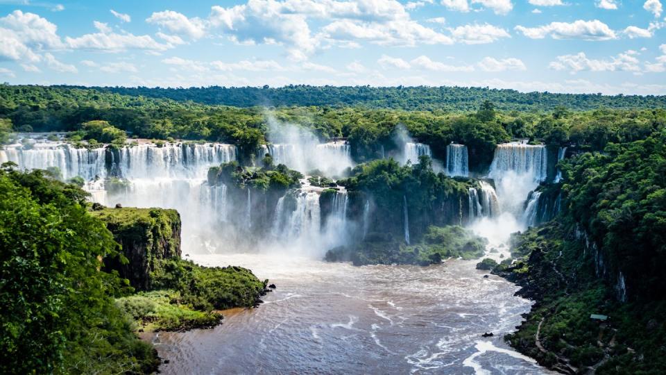 a large waterfall with trees around it