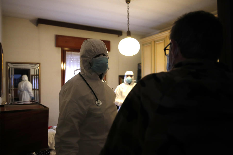 Doctor Luigi Cavanna and his nurse assistant Gabriele Cremona visit a patient in Piacenza, Italy, Wednesday, Dec. 2, 2020. Italy recorded another 814 deaths on Friday, Dec. 4, 2020 as the toll from the COVID-19 resurgence remained stubbornly high, bringing Italy’s pandemic total to 58,842. That is the second-highest death toll in Europe, behind Britain. (AP Photo/Antonio Calanni)