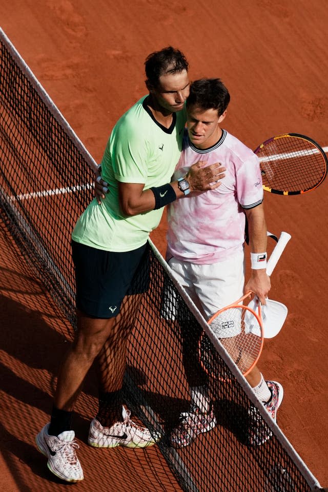 Rafael Nadal, left, consoles Diego Schwartzman at the net