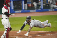 Chicago White Sox's Yoan Moncada, right, scores as Cleveland Indians' Roberto Perez stands near the plate during the seventh inning of a baseball game Thursday, Sept. 24, 2020, in Cleveland. (AP Photo/Tony Dejak)