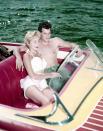 <p>Janet Leigh cozies up to her husband, Tony Curtis, in the front seat of a speed boat. Whether intentional or not, the <em>Psycho </em>actress<em>'</em>s red pout perfectly matches the interior of the vessel. </p>