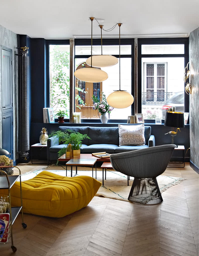 Le pouf Togo jaune safran dans un salon bleu nuit