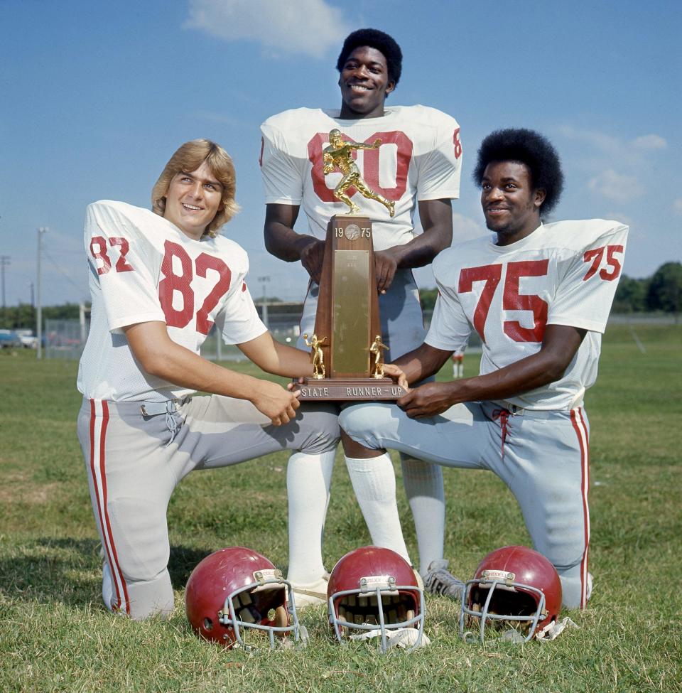 Maplewood High standouts end Jeff Goosetree, left, linebacker E.J. Junior and tackle William Smith pose with their 1975 TSSAA state runner up trophy.