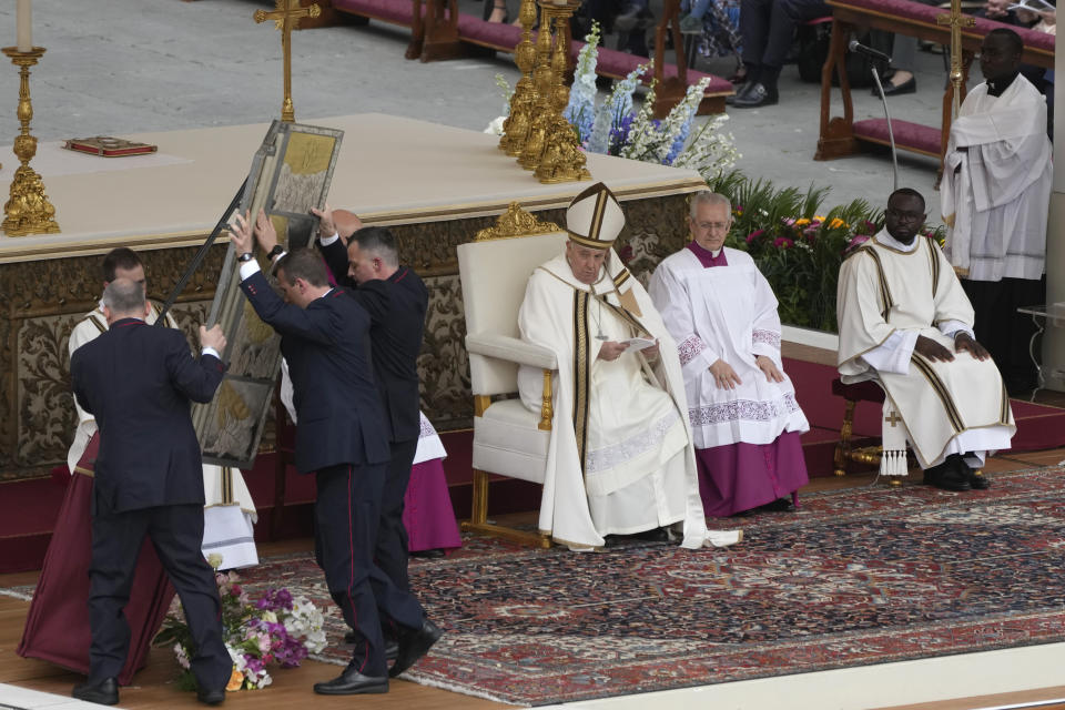 Vatican ushers raise the icon of the holy savior as Pope Francis celebrates Easter mass in St. Peter's Square at the Vatican, Sunday, March 31, 2024. (AP Photo/Alessandra Tarantino)