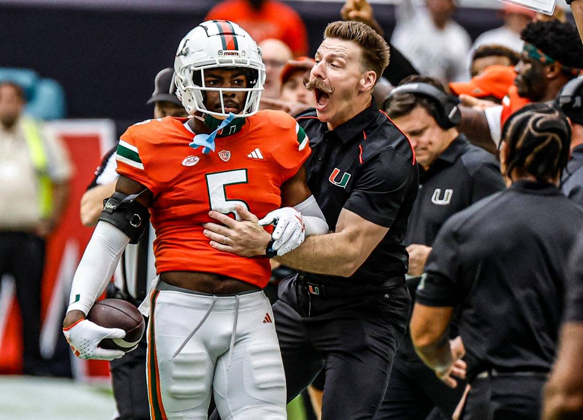 Miami Hurricanes strength and conditioning coach Aaron Feld reacts after safety Kamren Kinchens (5) intercepts a Louisville Cardinals pass in the first quarter on Saturday, November 18, 2023.