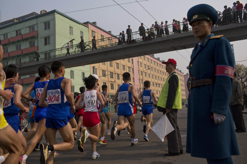 Runners pass under a pedestrian bridge in central Pyongyang during the running of the Mangyongdae Prize International Marathon in Pyongyang, North Korea on Sunday, April 13, 2014. The annual race, which includes a full marathon, a half marathon, and a 10-kilometer run, was open to foreign tourists for the first time this year. (AP Photo/David Guttenfelder)