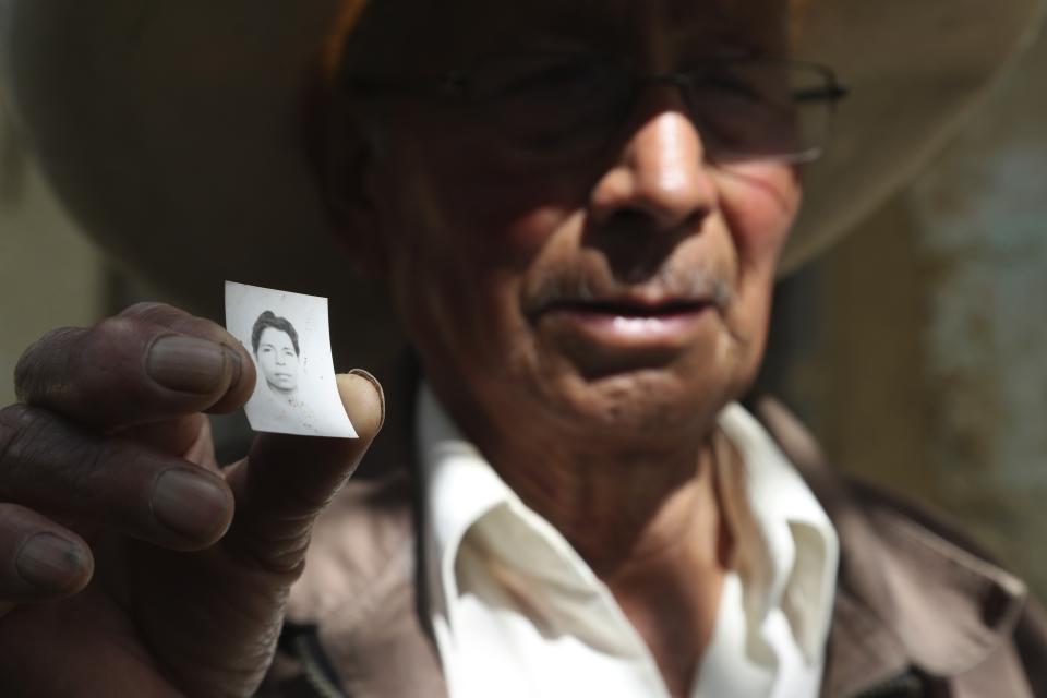 Ireño Castillo, the father of Free Peru party presidential candidate Pedro Castillo, shows an old photo of his son in Puna, Peru, Friday, April 16, 2021. Castillo's son, who has proposed rewriting Peru's constitution and deporting all immigrants living in the country illegally who commit crimes, will face rival candidate Keiko Fujimori in the June 6 presidential run-off election. (AP Photo/Martin Mejia)