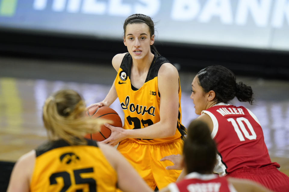 Iowa guard Caitlin Clark, center, looks to pass the ball during the first half of the team's NCAA college basketball game against Ohio State, Wednesday, Jan. 13, 2021, in Iowa City, Iowa. After Clark scored a career-high 37 points in the 92-79 win over Minnesota on January 6, Iowa coach Lisa Bluder said, “I think, in her four-year career, I’m going to run out of adjectives to describe her.”(AP Photo/Charlie Neibergall)