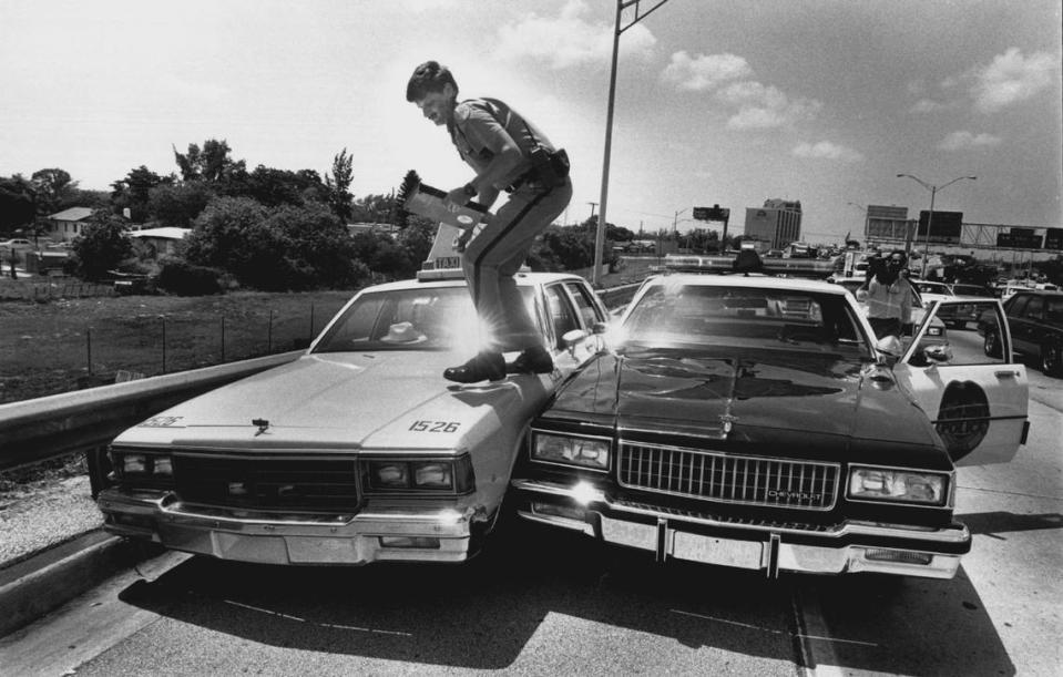 A highway trooper checks a taxi used as a bank robbery getaway car, on I-95 at Northwest 75th Street in 1989.