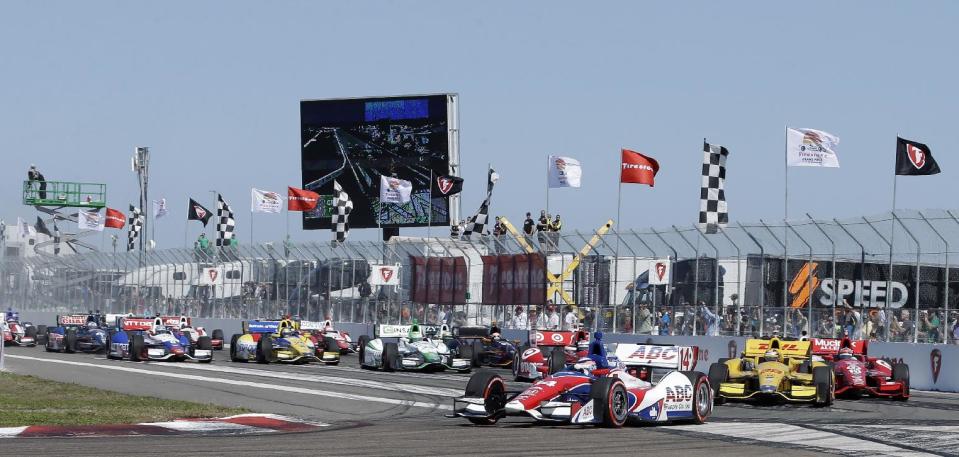 Takuma Sato, (14), of Japan, leads the field into the first turn at the start of the IndyCar Series auto race, Sunday, March 30, 2014, in St. Petersburg, Fla. (AP Photo/Chris O'Meara)