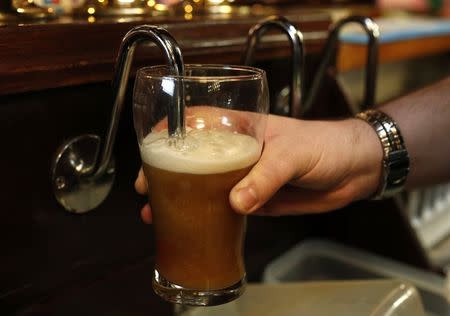 A barman pulls a pint of beer in a pub in Liverpool northern England November 19 , 2014. REUTERS/Phil Noble