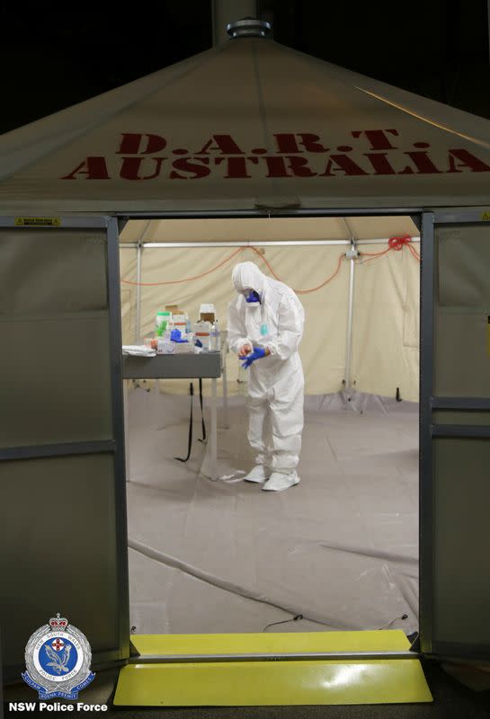 NSW Police personnel gear up in personal protective equipment for the Strike Force Bast raid of the Ruby Princess cruise ship at Port Kembla