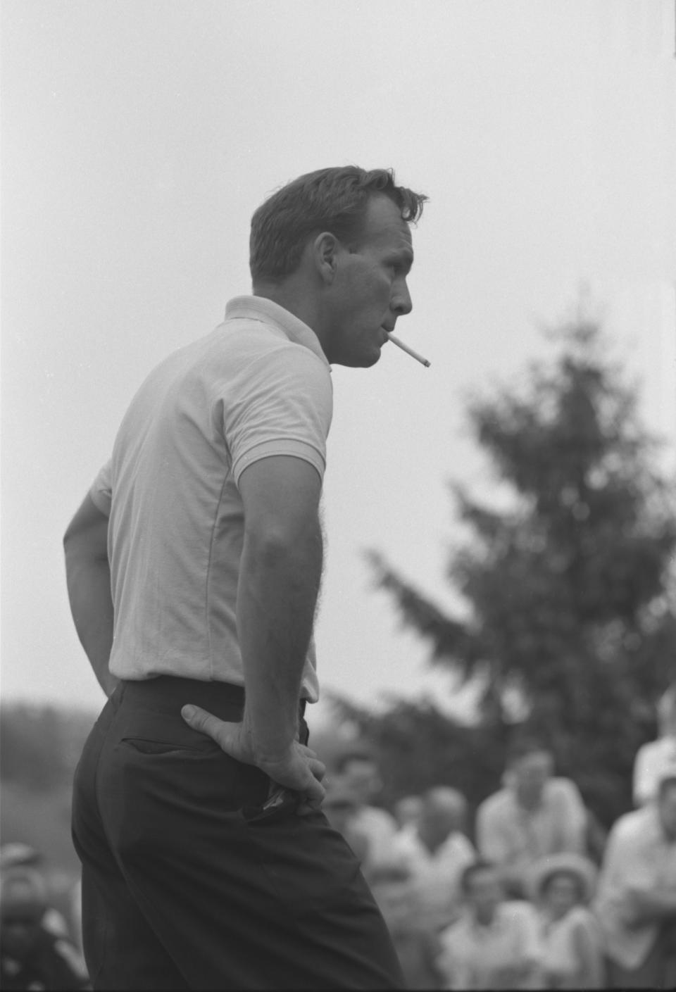 Pro Golfer Arnold Palmer smoking on green while crowd watches . Augusta, Georgia May 1962 Photographer- John Dominis Time Inc Owned Merlin- 1143150