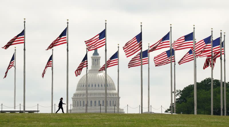 A woman walks among flags at the Washington Monument during the coronavirus disease (COVID-19) pandemic in Washington