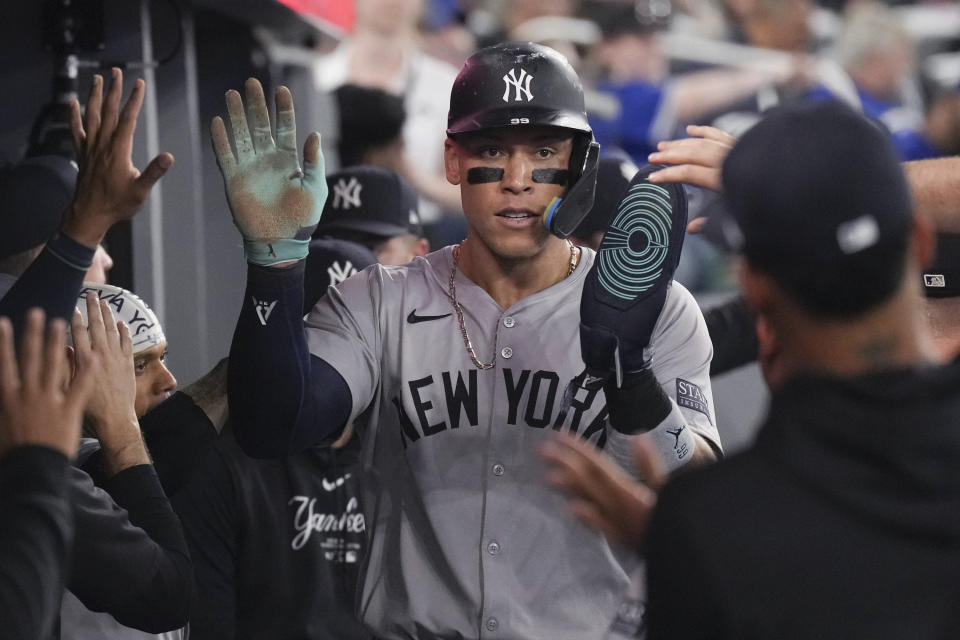 New York Yankees Aaron Judge is congratulated after scoring on a double by J.D. Davis against the Toronto Blue Jays during the sixth inning of a baseball game Friday, June 28, 2024, in Toronto. (Chris Young/The Canadian Press via AP)