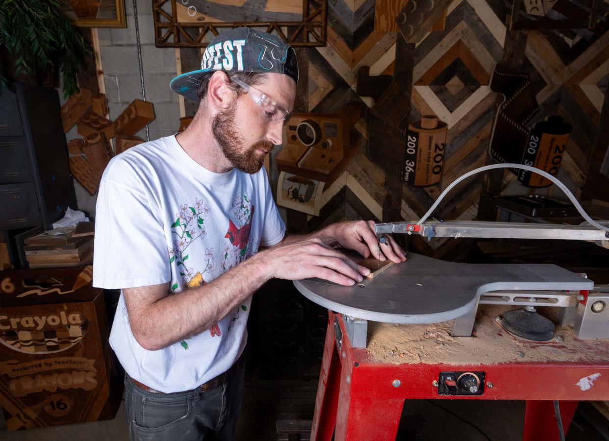 Wisconsin wood artist Ike Wynter, who uses discarded wood to make art that focuses on nostalgia and mental health awareness, works on an art piece on Wednesday, June 12, 2024, in Butler, Wisconsin.