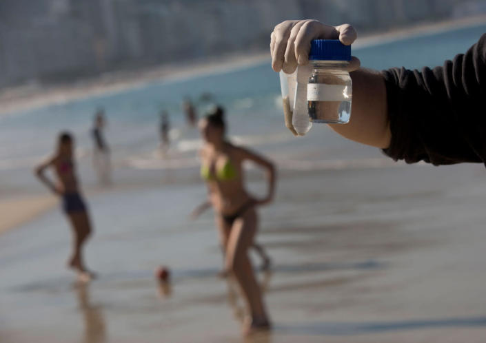 <p>In this July 11, 2016 photo, doctoral candidate Rodrigo Staggemeier shows samples of water and sand from Copacabana Beach, collected for a study commissioned by The Associated Press, in Rio de Janeiro, Brazil. A 16-month review of the aquatic Olympic and Paralympic venues has revealed consistent and dangerously high levels of illness-causing viruses from the human sewage pollution that has become a major black eye on Rio’s Olympic project and set off alarm bells among sailors, rowers and open-water swimmers. (AP Photo/Silvia Izquierdo)