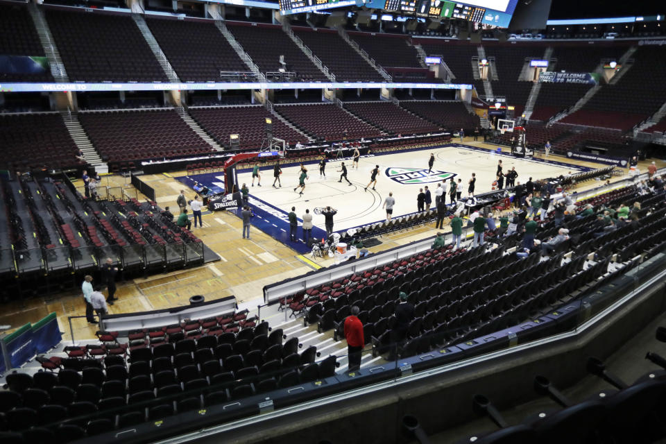 Ohio University basketball players warm up in an empty arena without fans before an NCAA college basketball game against Akron in the Mid-American Conference men's tournament, Thursday, March 12, 2020, in Cleveland. The Mid-American Conference tournament was cancelled Thursday, at an arena scheduled to be the site of NCAA men's tournament games next week .(AP Photo/Tony Dejak)