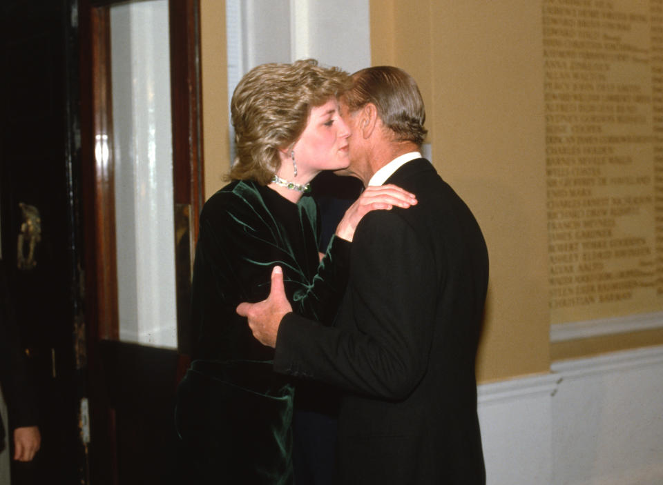 LONDON, ENGLAND - MARCH 19: Diana, Princess of Wales, wearing a green velvet dress designed by Victor Edelstein and an emerald choker necklace, kisses her father-in-law, Prince Philip, Duke of Edinburgh on the cheek as she arrives to attend a dinner at the Royal Society of Arts on March 19, 1986 in London, United Kingdom. (Photo by Anwar Hussein/Getty Images)