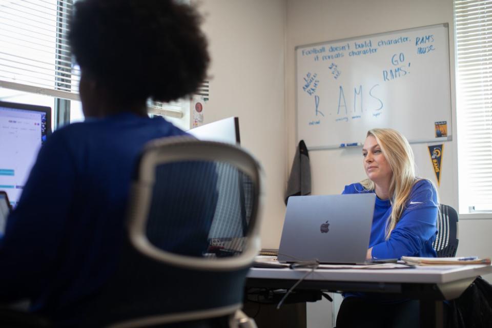 Sophie Harlan, Rams director of operations, and her team work in front of computers.