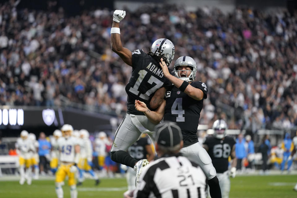 Las Vegas Raiders quarterback Derek Carr (4) and wide receiver Davante Adams (17) celebrate their touchdown during the second half of an NFL football game against the Los Angeles Chargers, Sunday, Dec. 4, 2022, in Las Vegas. (AP Photo/Matt York)