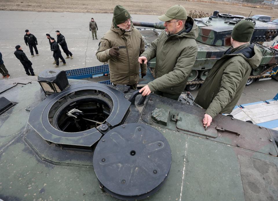 Ukraine's prime minister and defense minister  stand on one of the first Leopard 2 tanks delivered from Poland on a day of the first anniversary of Russia's attack on Ukraine, in an undisclosed location, Ukraine February 24, 2023.