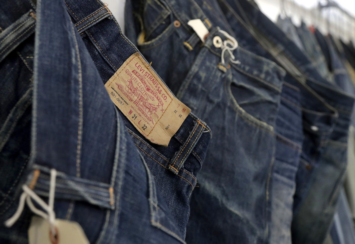 FILE- This Feb. 9, 2018 photo shows Levi's jeans hanging on a wall at Levi's innovation lab in San Francisco. On Thursday, March 21, 2019, Levi Strauss & Co. is going back to the public markets after 34 years. (AP Photo/Jeff Chiu, File)