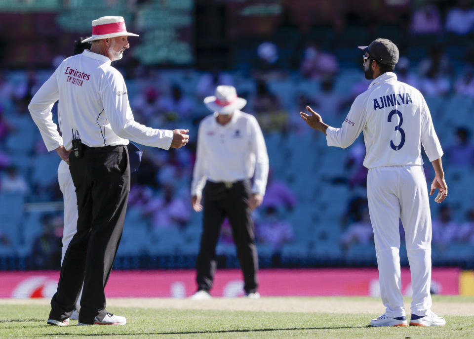 Indian captain Ajinkya Rahane, right, gestures as he speaks with umpire Paul Wilson during play on day three of the third cricket test between India and Australia at the Sydney Cricket Ground, Sydney, Australia, Saturday, Jan. 9, 2021. (AP Photo/Rick Rycroft)