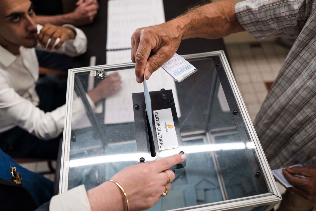 A french citizen is seeing casting his ballot at a polling station while voting during the second round of french legislative elections opposing hereduring the second round of french legislative elections opposing here, Claudie Chretien, NFP (Nouveau Front Populaire) candidate against Marine Hamelet RN (Rassemblement National), in Moissac, France on 7 July 2024.