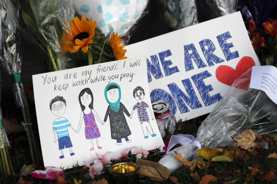 A message card is placed at a collection of flowers left at the Botanical Gardens in Christchurch, New Zealand, Saturday, March 16, 2019. New Zealand's stricken residents reached out to Muslims in their neighborhoods and around the country on Saturday, in a fierce determination to show kindness to a community in pain as a 28-year-old white supremacist stood silently before a judge, accused in mass shootings at two mosques that left dozens of people dead. (AP Photo/Vincent Thian)