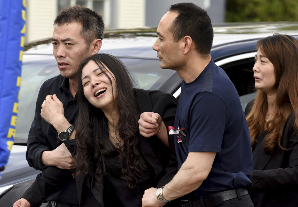 FILE - Peter Wang's mother, Hui, cries as she is helped into a waiting car with her family after the memorial service for her 15-year-old son at Kraeer Funeral Home in Coral Springs, Fla., Tuesday, Feb. 20, 2018. Peter Wang is a victim in the shooting at Marjory Stoneman Douglas High School. (Taimy Alvarez/South Florida Sun-Sentinel via AP, File)