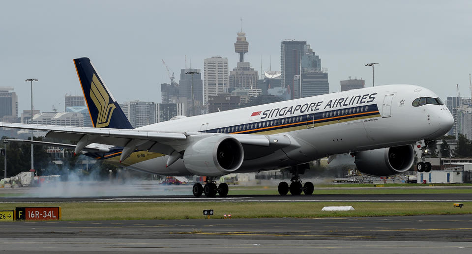 A Singapore Airlines flight touches down at Sydney International Airport.