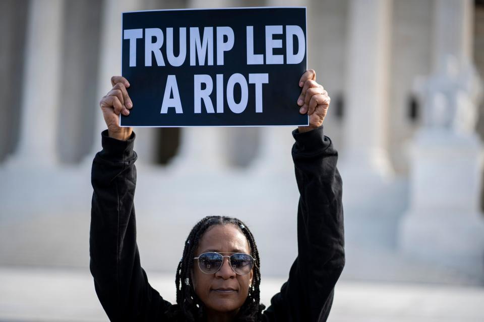 Valarie Walker of New York City raises her sign as protestors gather outside the United States Supreme Court as the court reviews a ruling by a Colorado court that barred former President Donald Trump from appearing on the state’s Republican primary ballot due to his role in the Jan. 6, 2021 attacks on the U.S. Capitol.