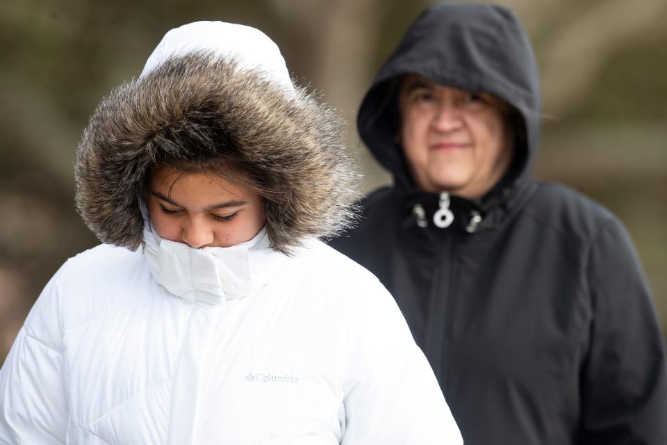 People walk along Oso Creek in freezing temperatures on Monday, Feb. 15, 2021.