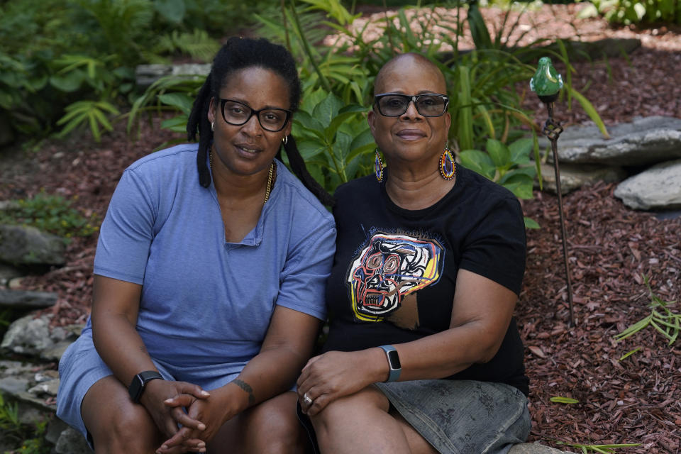Angelique Webster, of Worcester, Mass., left, an independent filmmaker, and her mother Gloria Webster, right, who is retired and lives in Raleigh, N.C., pose, Thursday, Sept. 7, 2023, in a garden behind Angelique's home, in Worcester. Black victims have largely been invisible in the Catholic sexual abuse crisis, including Baltimore, where Angelique was abused by their parish priest. Gloria fought hard for justice. The priest was later convicted and defrocked. The family settled with the archdiocese in 1993. (AP Photo/Steven Senne)