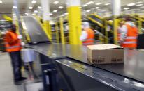 A parcel travels along a conveyer belt at Amazon's new distribution center in Brieselang, near Berlin November 28, 2013. Germany's antitrust watchdog has dropped an investigation into Amazon after the world's biggest Internet retailer agreed to stop forcing third-party merchants to offer their cheapest price when selling products on its platform. Andreas Mundt, the president of the German cartel office, said it had decided to set aside the case against Amazon after the company agreed to cancel that demand from the terms and conditions of its contracts with merchants. "Making pricing demands to your own competitors cannot be justified in any circumstances, not even with the undeniable advantages of an online market place." REUTERS/Tobias Schwarz