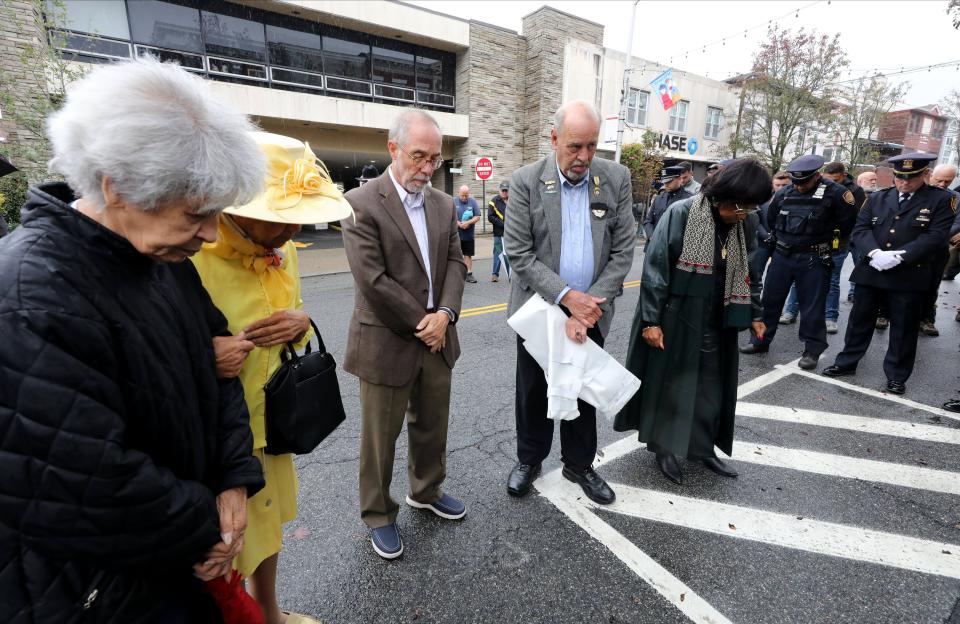 Don Hammond, third from left, the mayor of the Village of Nyack along with others, observe a moment of silence after unveiling a street sign renaming Lydecker Street after slain Nyack Police Sgt. Edward O'Grady and Officer Waverly "Chipper" Brown, Oct. 20, 2023.