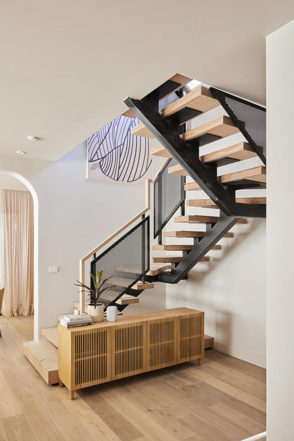 A shot of the black and brown staircase and a brown rattan cupboard. 